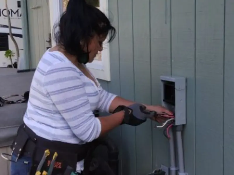 Licensed electrician wiring an exterior subpanel in DeWitt